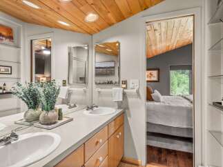 Experience modern comfort in this beautifully appointed bathroom featuring a dual vanity with ample counter space and elegant wood cabinetry.