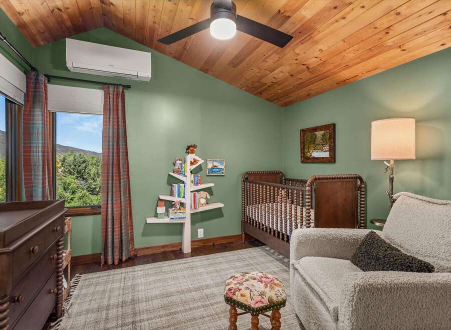 This charming nursery features a rustic wooden crib and a matching changing table, perfect for a cozy and inviting space.