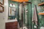 Experience luxury in this stunning bathroom featuring a modern vanity with a dark wood cabinet and a sleek countertop.
