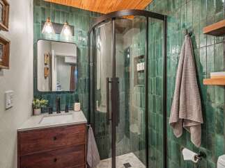 Experience luxury in this stunning bathroom featuring a modern vanity with a dark wood cabinet and a sleek countertop.