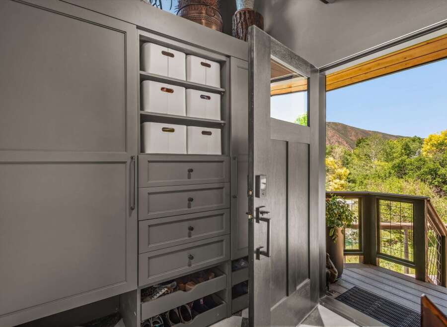 Step into this welcoming entryway featuring a custom built-in storage unit with ample shelving and drawers, perfect for organizing shoes and accessories.
