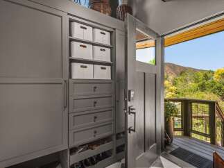 Step into this welcoming entryway featuring a custom built-in storage unit with ample shelving and drawers, perfect for organizing shoes and accessories.