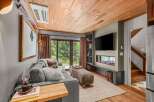 Experience cozy living in this mountain retreat, featuring a modern electric fireplace and a large flat-screen TV.