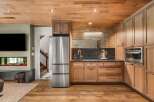 Experience modern living with this stunning kitchen featuring sleek stainless steel appliances, including a refrigerator and built-in oven.