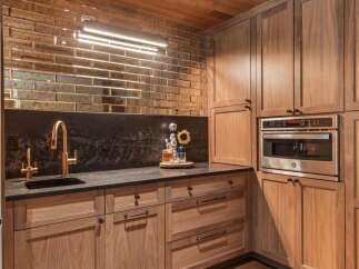 Experience luxury in this stunning kitchen featuring a unique mirrored subway tile backsplash and a sleek black granite countertop.