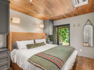 Experience serene living in this beautifully appointed bedroom, featuring a plush velvet headboard and a cozy, nature-inspired color palette.