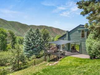 Experience breathtaking mountain views from this stunning green home, featuring a spacious deck perfect for outdoor entertaining.