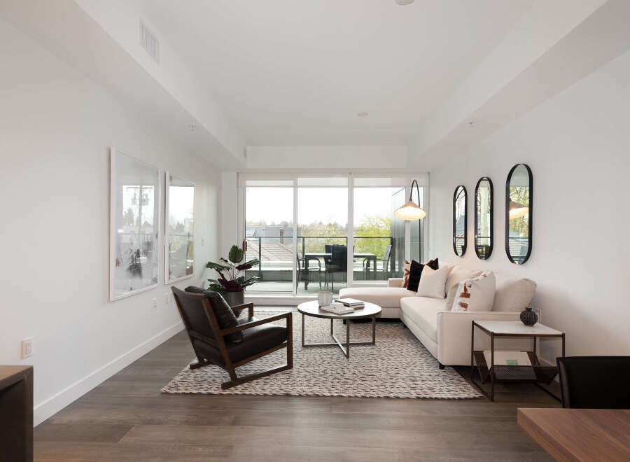 Experience modern living in this bright and airy living room, featuring a comfortable sectional sofa and a stylish accent chair.