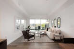 Experience modern living in this bright and airy living room, featuring a comfortable sectional sofa and a stylish accent chair.