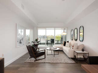 Experience modern living in this bright and airy living room, featuring a comfortable sectional sofa and a stylish accent chair.