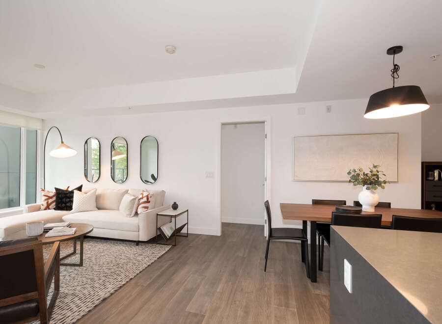 Experience modern living in this beautifully appointed open-concept space, featuring a comfortable sectional sofa and a stylish dining area perfect for entertaining.