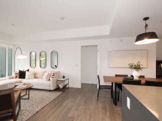 Experience modern living in this beautifully appointed open-concept space, featuring a comfortable sectional sofa and a stylish dining area perfect for entertaining.