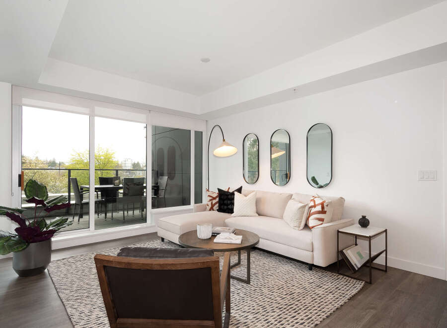 Experience modern living in this bright and airy living room, featuring a comfortable sectional sofa adorned with stylish throw pillows.