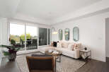 Experience modern living in this bright and airy living room, featuring a comfortable sectional sofa adorned with stylish throw pillows.