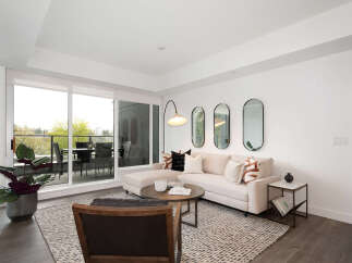 Experience modern living in this bright and airy living room, featuring a comfortable sectional sofa adorned with stylish throw pillows.