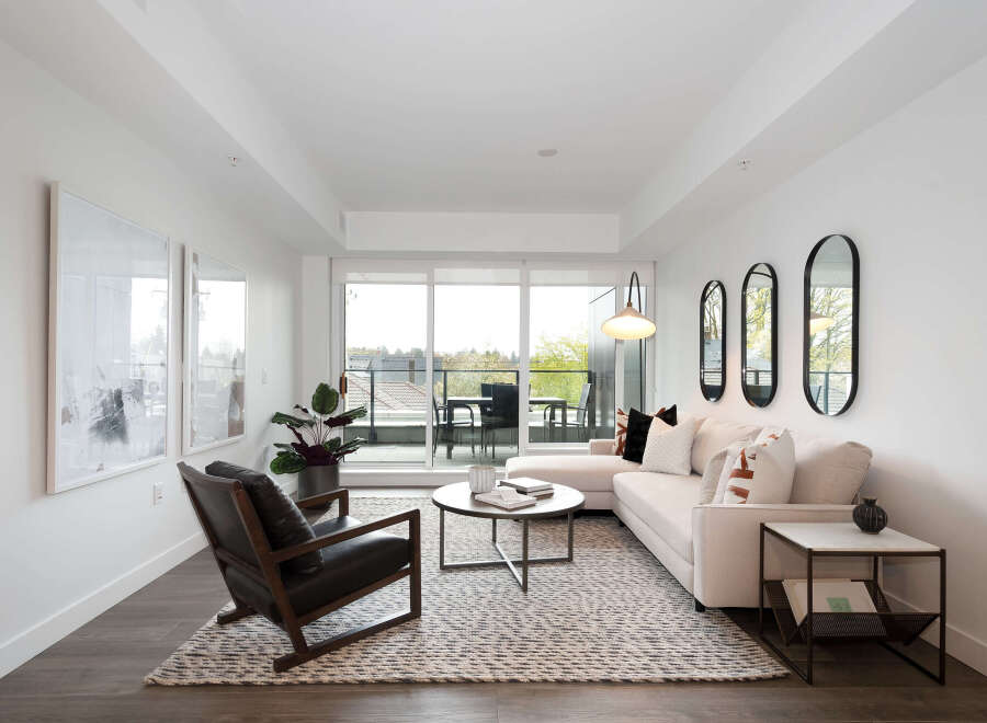 Experience modern living in this bright and airy living room, featuring a plush sectional sofa and a stylish leather armchair.
