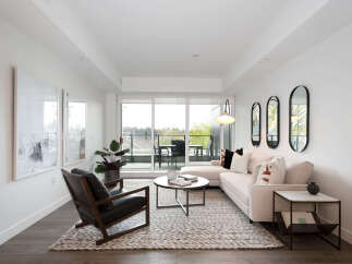 Experience modern living in this bright and airy living room, featuring a plush sectional sofa and a stylish leather armchair.