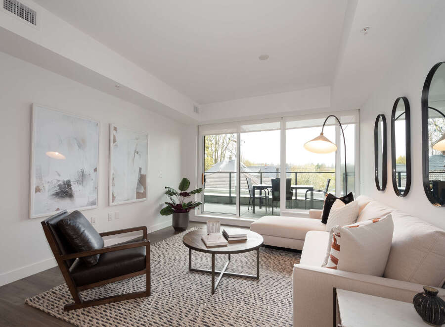Experience modern living in this bright and airy living room, featuring a comfortable sectional sofa and a stylish accent chair.
