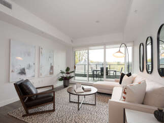 Experience modern living in this bright and airy living room, featuring a comfortable sectional sofa and a stylish accent chair.