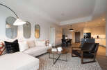 Experience modern living in this stylish open-concept apartment, featuring a spacious living area with a comfortable sectional sofa and a chic coffee table.