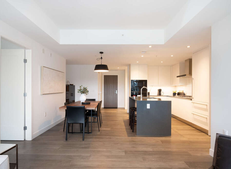 Experience modern living in this stunning open-concept condo featuring a sleek kitchen with a large island and ample cabinet space.