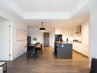 Experience modern living in this stunning open-concept condo featuring a sleek kitchen with a large island and ample cabinet space.