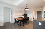 This modern dining area features a sleek wooden table with black chairs, perfect for intimate gatherings.