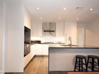 Experience modern living in this sleek kitchen featuring high-end stainless steel appliances, including a built-in microwave and oven.