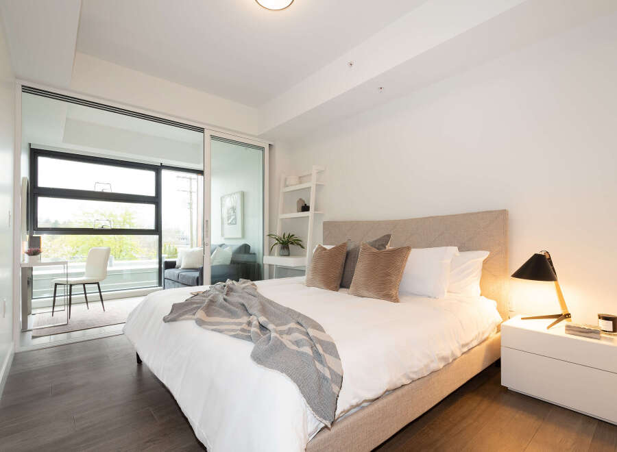Experience modern living in this beautifully appointed bedroom, featuring a plush king-sized bed with luxurious linens and a stylish upholstered headboard.