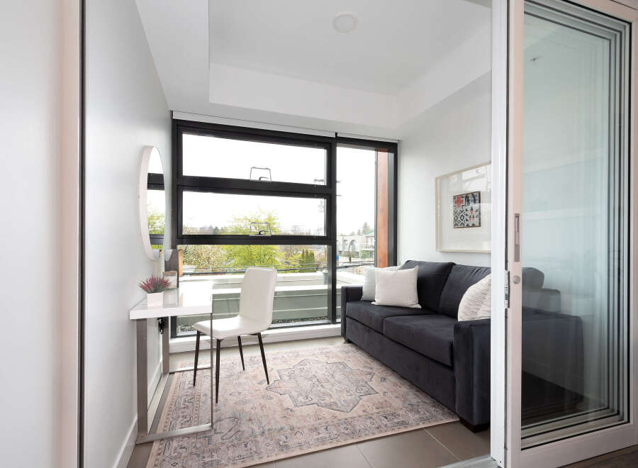 This modern living space features a comfortable dark gray sofa adorned with plush pillows, perfect for relaxation.