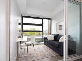This modern living space features a comfortable dark gray sofa adorned with plush pillows, perfect for relaxation.