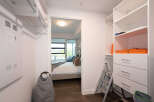 Step into this spacious walk-in closet, featuring ample shelving and drawers for all your storage needs.