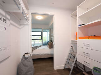 Step into this spacious walk-in closet, featuring ample shelving and drawers for all your storage needs.
