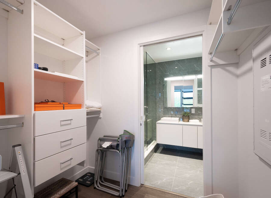 Step into this spacious walk-in closet, featuring ample shelving and drawers for organized storage.