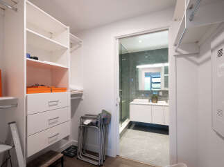 Step into this spacious walk-in closet, featuring ample shelving and drawers for organized storage.