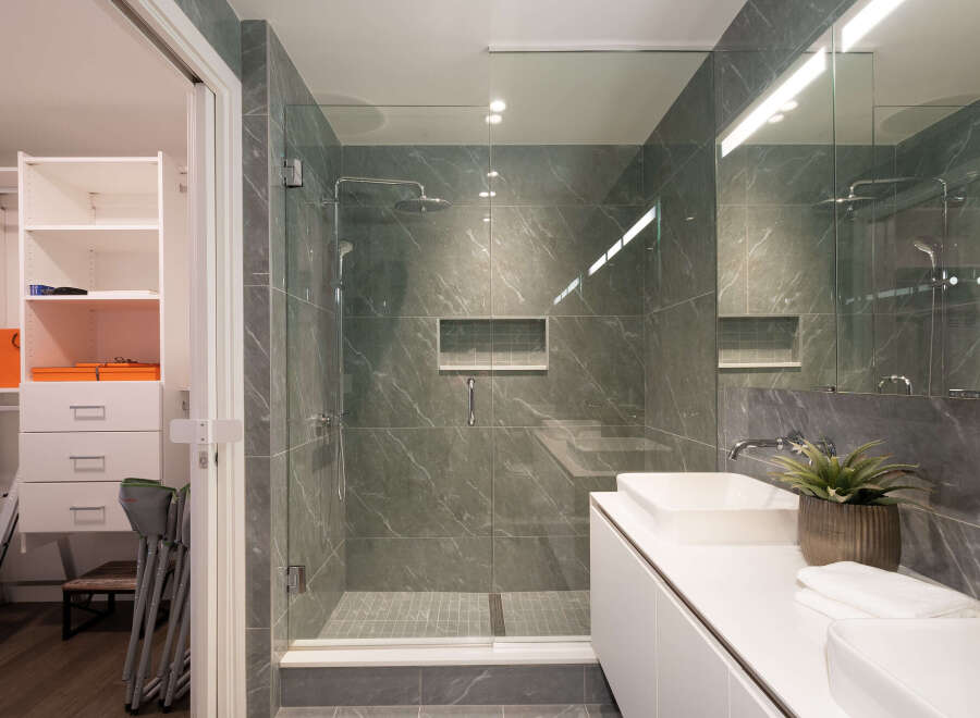 Experience modern luxury in this stunning bathroom featuring a spacious walk-in shower with elegant marble-look tiles and a sleek glass enclosure.