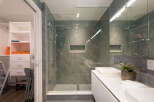 Experience modern luxury in this stunning bathroom featuring a spacious walk-in shower with elegant marble-look tiles and a sleek glass enclosure.