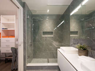 Experience modern luxury in this stunning bathroom featuring a spacious walk-in shower with elegant marble-look tiles and a sleek glass enclosure.