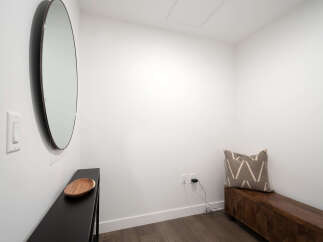 This entryway features a sleek black console table topped with a decorative wooden bowl, perfect for keys or mail.