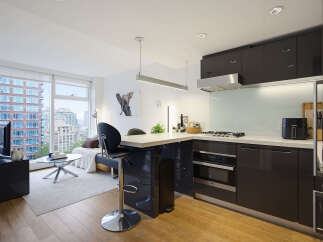 Experience modern urban living in this stylish studio apartment featuring a sleek, contemporary kitchen with dark cabinetry and stainless steel appliances.
