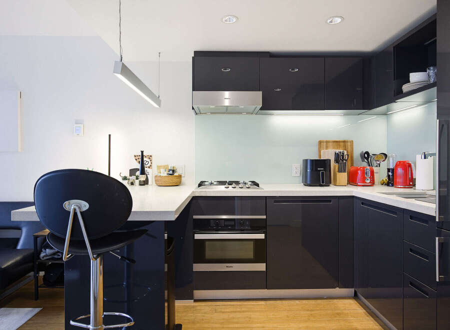 Discover this modern kitchen featuring sleek, dark cabinetry and a clean, minimalist aesthetic.