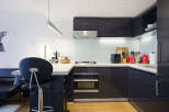 Discover this modern kitchen featuring sleek, dark cabinetry and a clean, minimalist aesthetic.