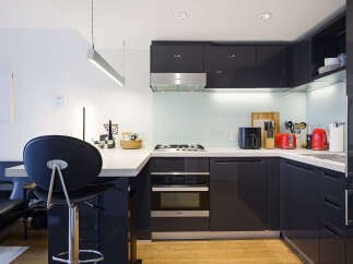 Discover this modern kitchen featuring sleek, dark cabinetry and a clean, minimalist aesthetic.