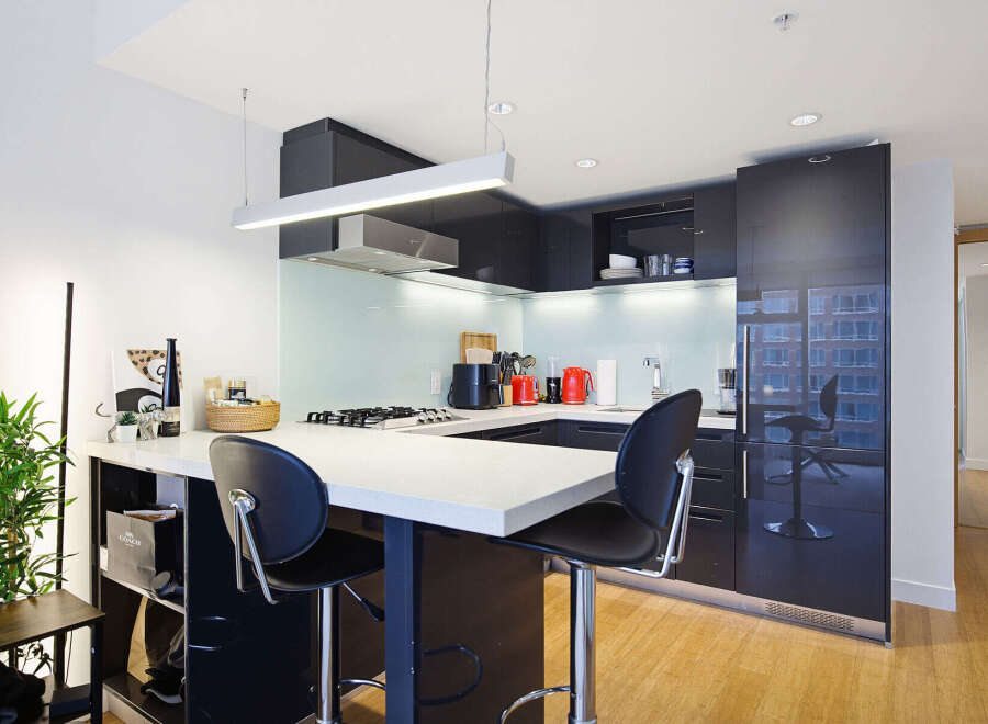 Experience modern urban living in this sleek kitchen featuring a spacious island with bar seating, perfect for casual dining or entertaining.