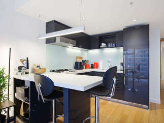 Experience modern urban living in this sleek kitchen featuring a spacious island with bar seating, perfect for casual dining or entertaining.
