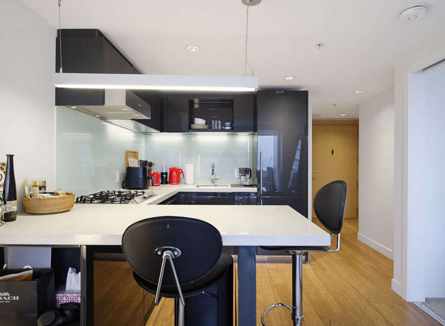 Experience modern urban living in this sleek kitchen, featuring high-gloss cabinetry and a stylish backsplash.