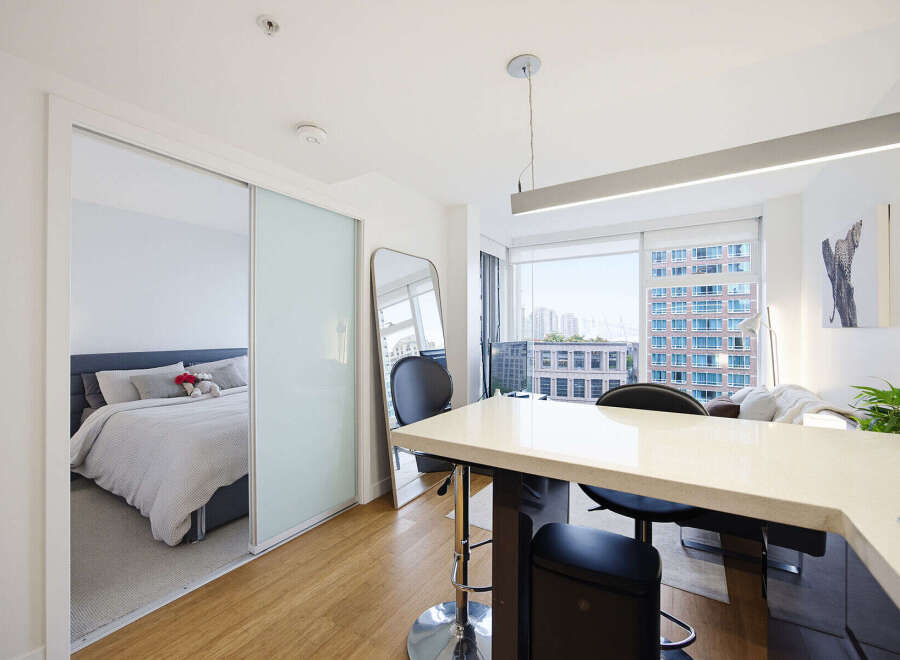 Experience modern urban living in this stylish studio apartment, featuring a sleek open-concept layout with a dedicated sleeping area separated by elegant sliding doors.