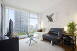 Experience modern city living in this stylish apartment featuring a sleek black sofa and a chic glass coffee table.