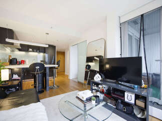 Experience modern urban living in this stylish apartment featuring a sleek, open-plan kitchen with a breakfast bar and contemporary cabinetry.