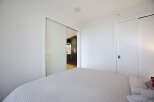 Experience modern living in this bright bedroom featuring a comfortable bed with a textured comforter.